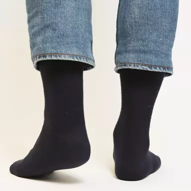 Person trägt scharze Socken und Jeans.